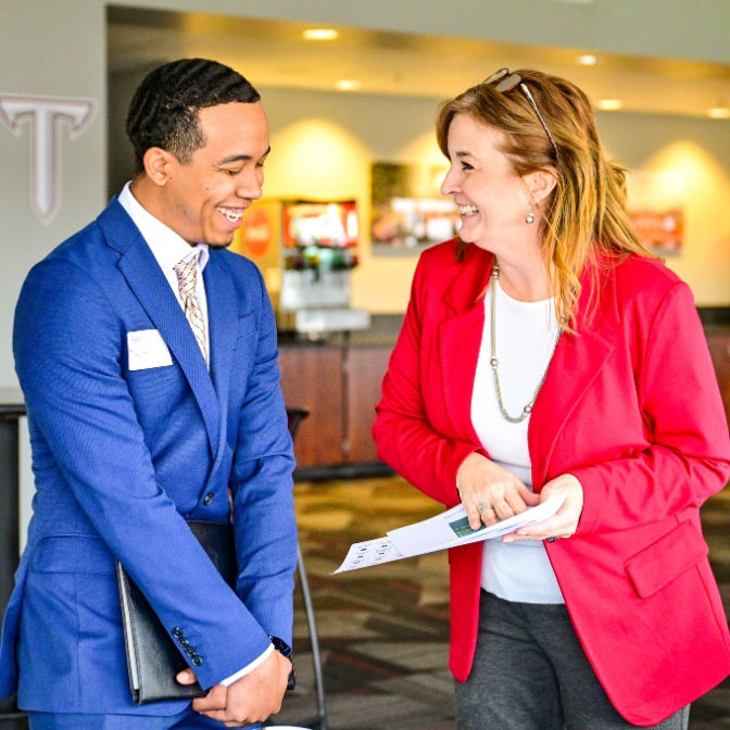 Student and employer talking with one another at career fair