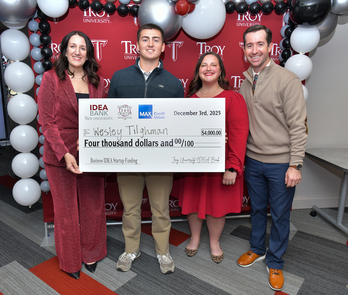 college boy holding a big check for 1st place prize of $4,000 from max credit union 