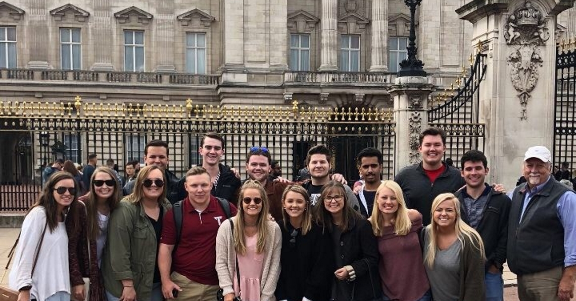 Risk Management and Insurance students on their study abroad trip to London, England posing in front of Buckingham Palace