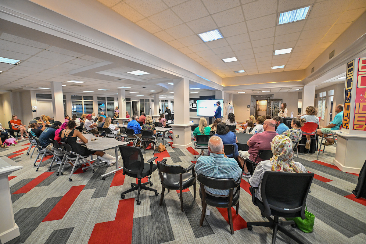 Group of people in a room watching a bpitch presentation