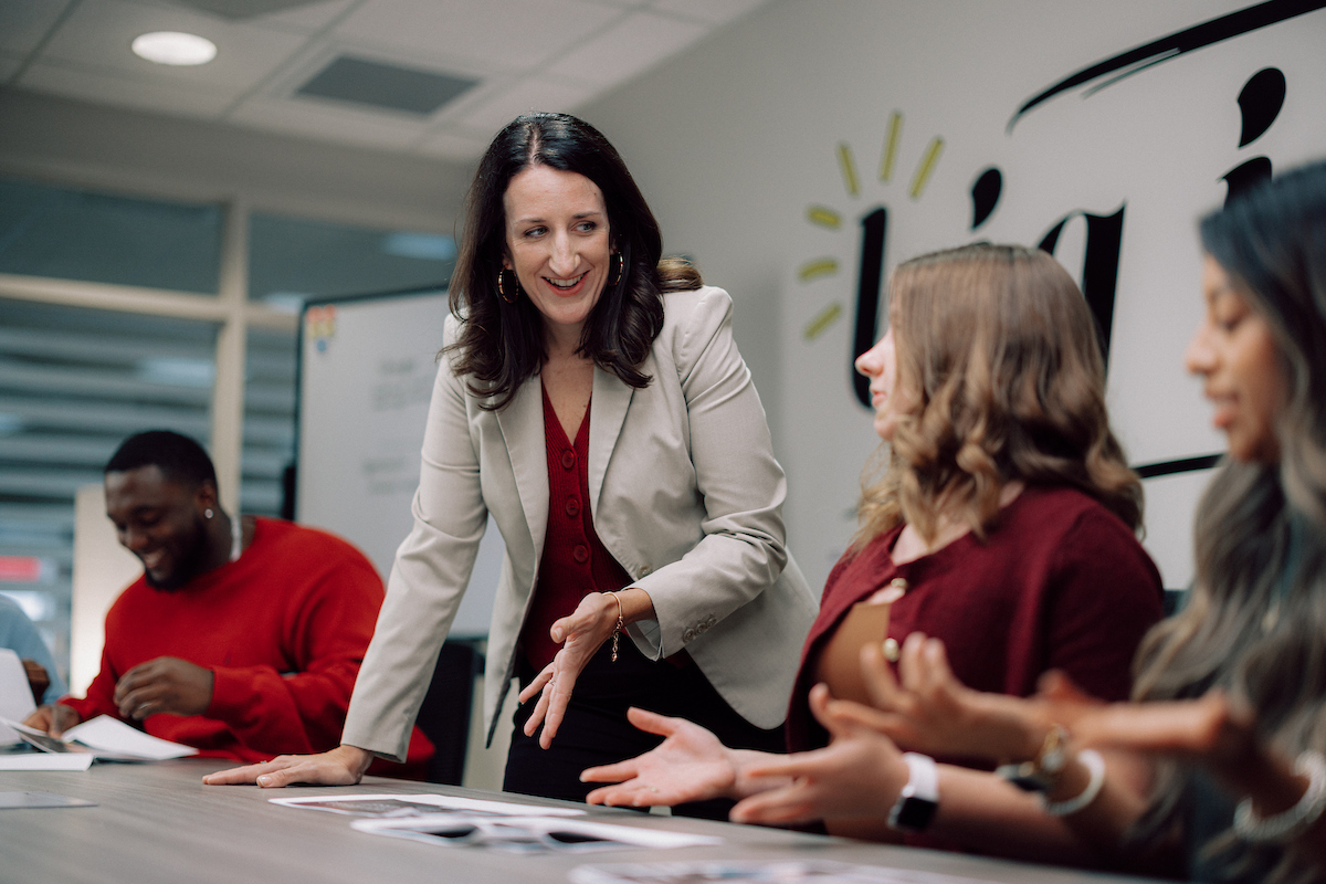 Director of Troy University IDEA Bank helping a student with a piece of paper.
