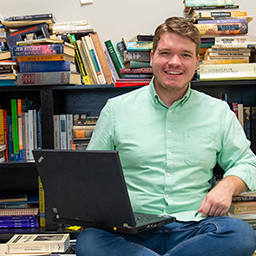 Student sitting in front of books