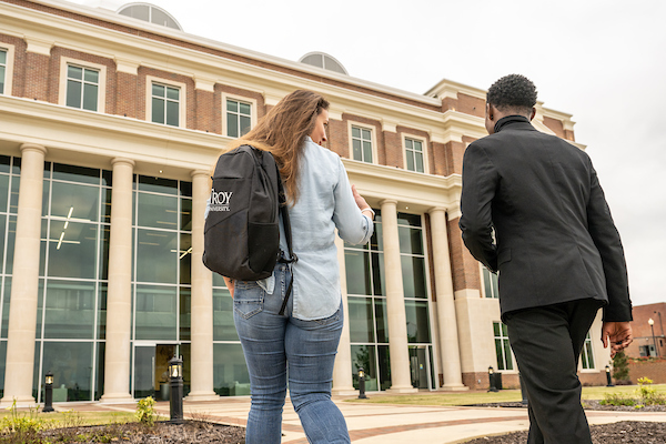 Two students walking into Jones Hall for class. 