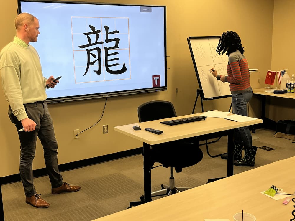 Students writing the character for dragon in Chinese