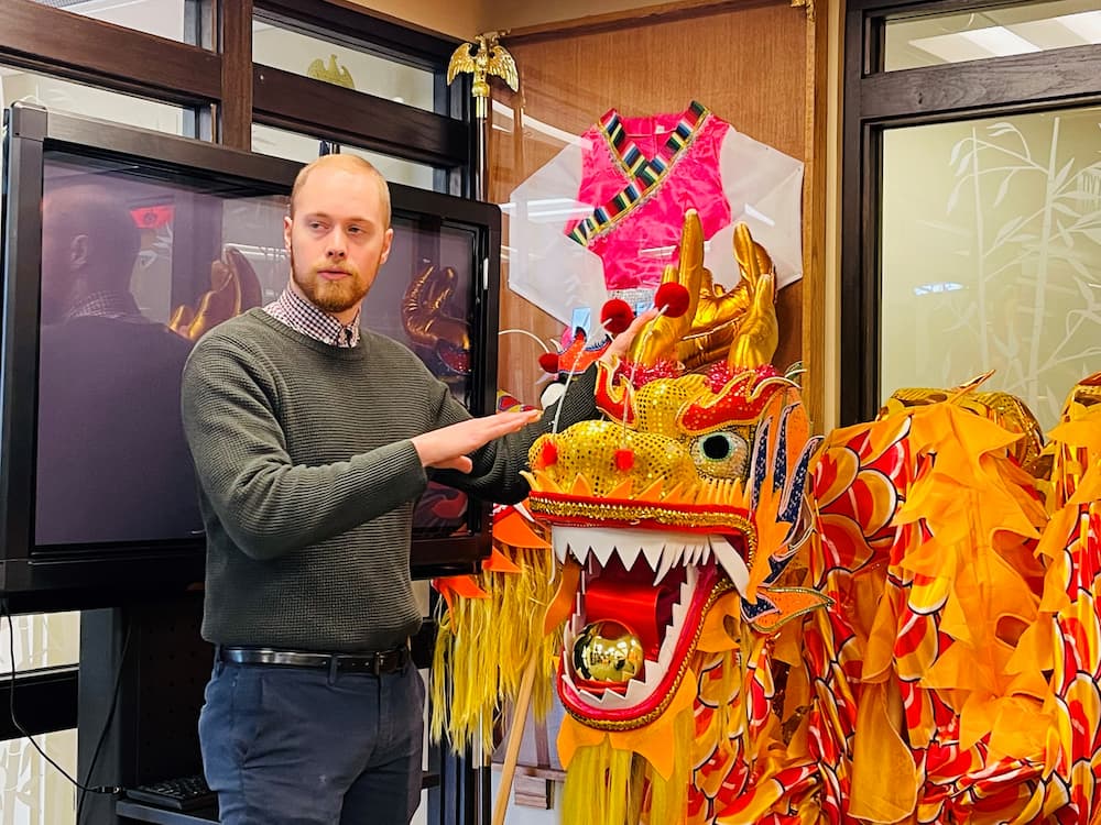 Associate Director Austin Deal posing with the dragon costume