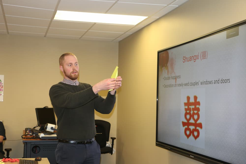 Associate Director Austin Deal showing everyone how to make the spring paper cut