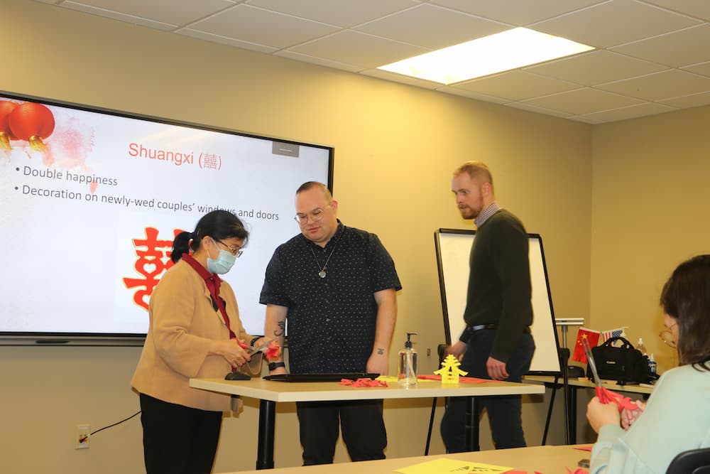 Dr. Xu helping Assistant Jon Garrett cut paper