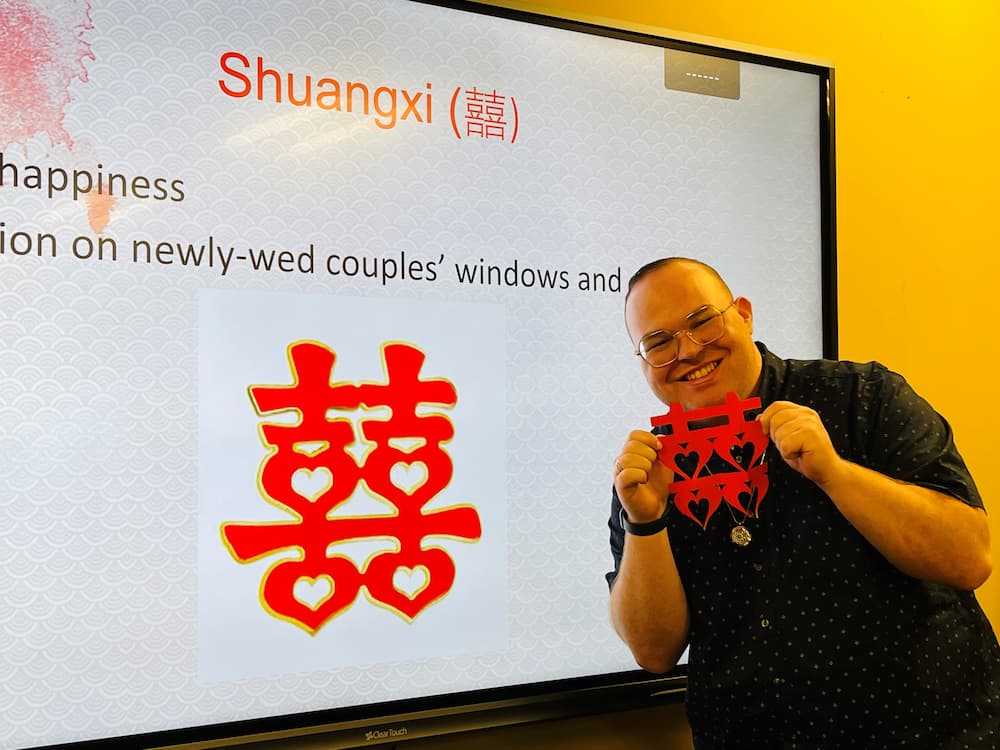 Assistant Jon Garrett posing with his double-happiness paper cut
