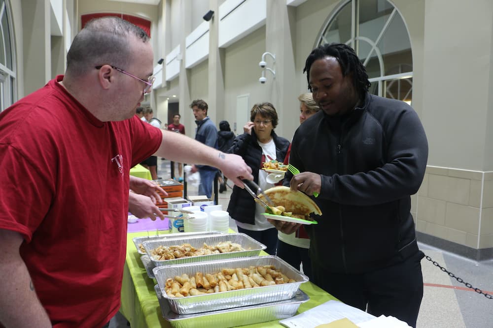 Assistant Jon Garrett serving Chinese food to the public