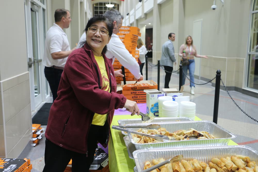 Dr. Xu posing for the camera in between serving food