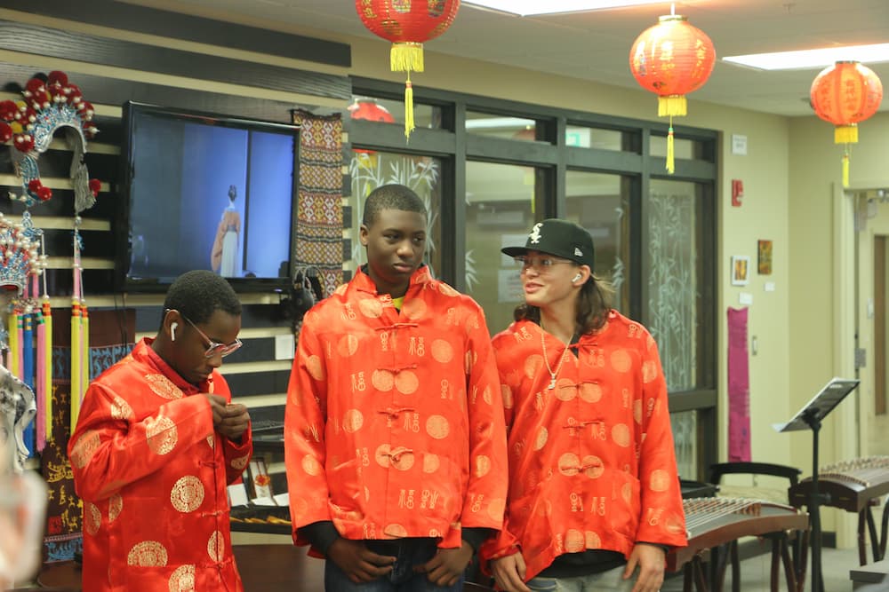 Three students dressed in traditional Chinese clothing