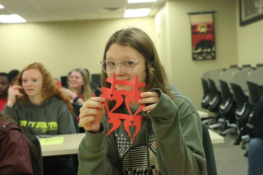 A student showing off their double happiness Chinese paper cut