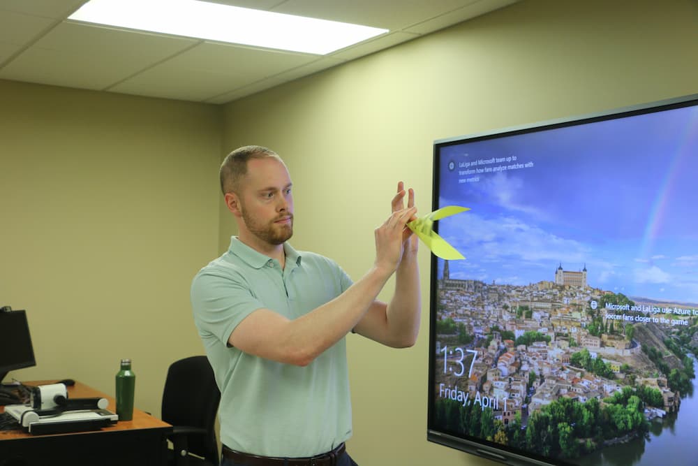 Associate Director Austin Deal showing how to fold the paper for the Spring Chinese paper cut