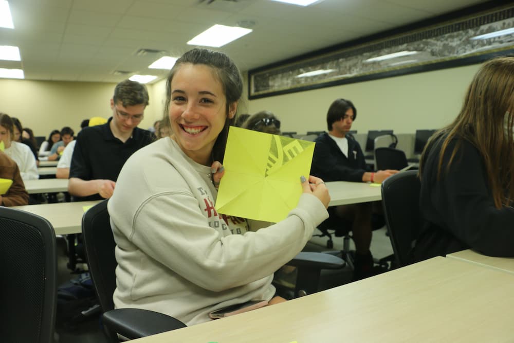 Troy student showing their paper folds and getting ready to start cutting