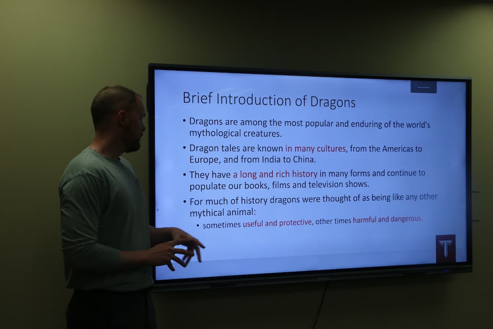 Associate Director Austin Deal giving a presentation on the history of dragons