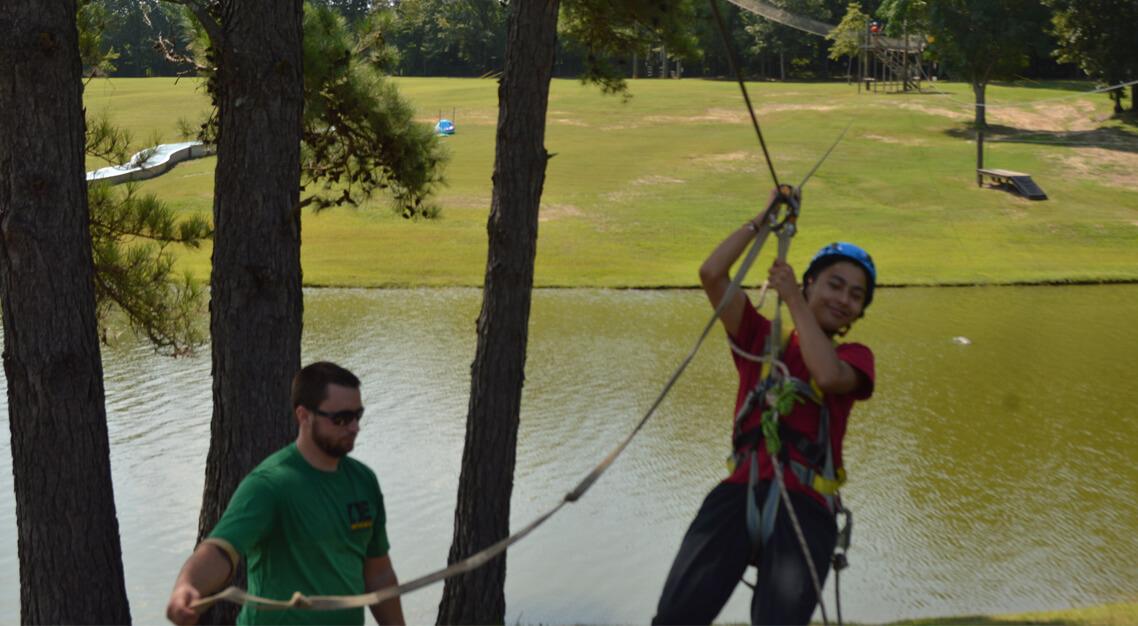 New student landing on the zipline at Camp Butter and Egg during Orientation.