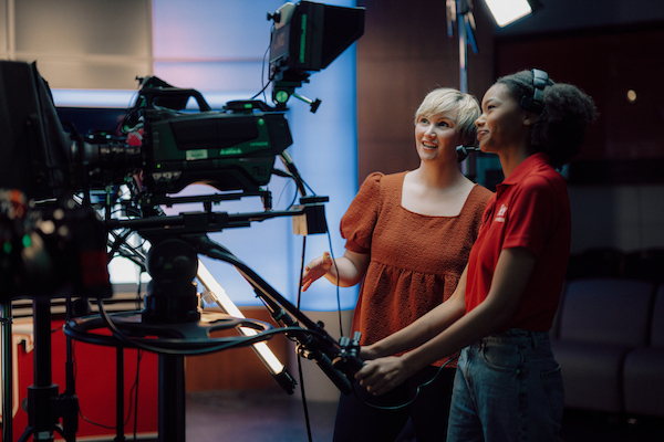 Paige Ray and her student in the studion guiding the camera
