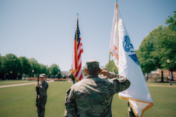 ROTC cadets saluting as they present colors.