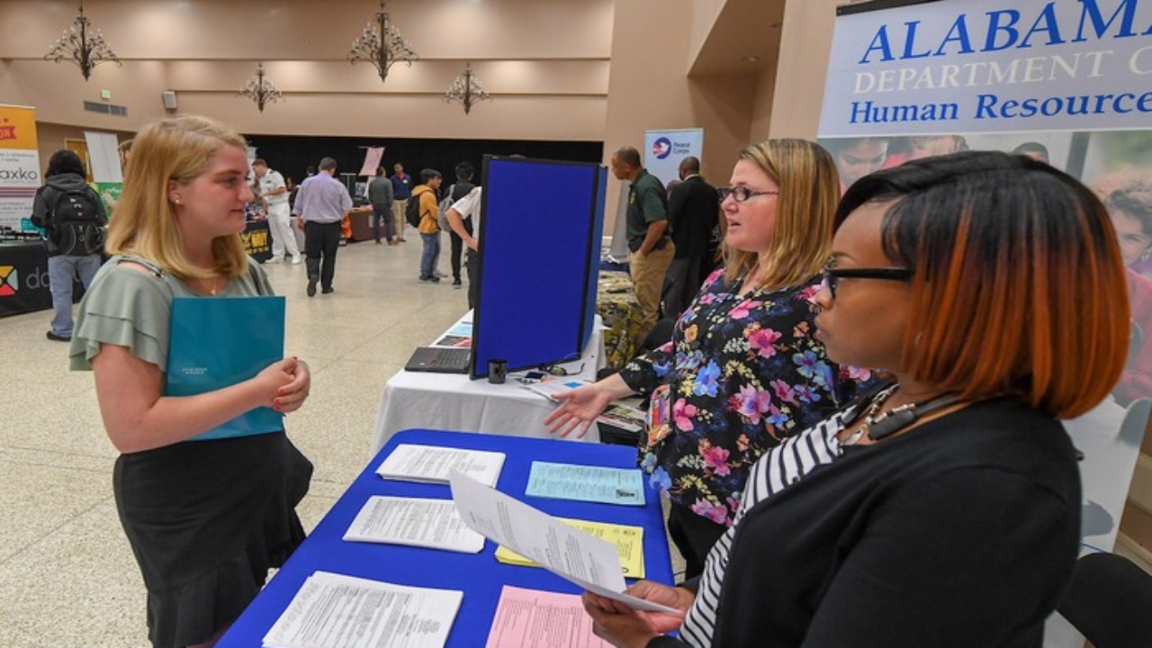 A student talks to employers about internship opportunities at a TROY career fair.
