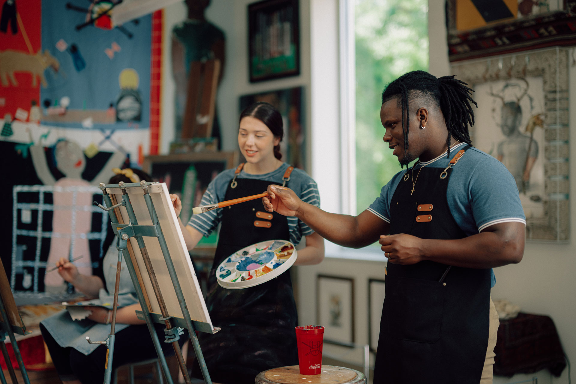 A TROY art education professor instructs students during a painting class.