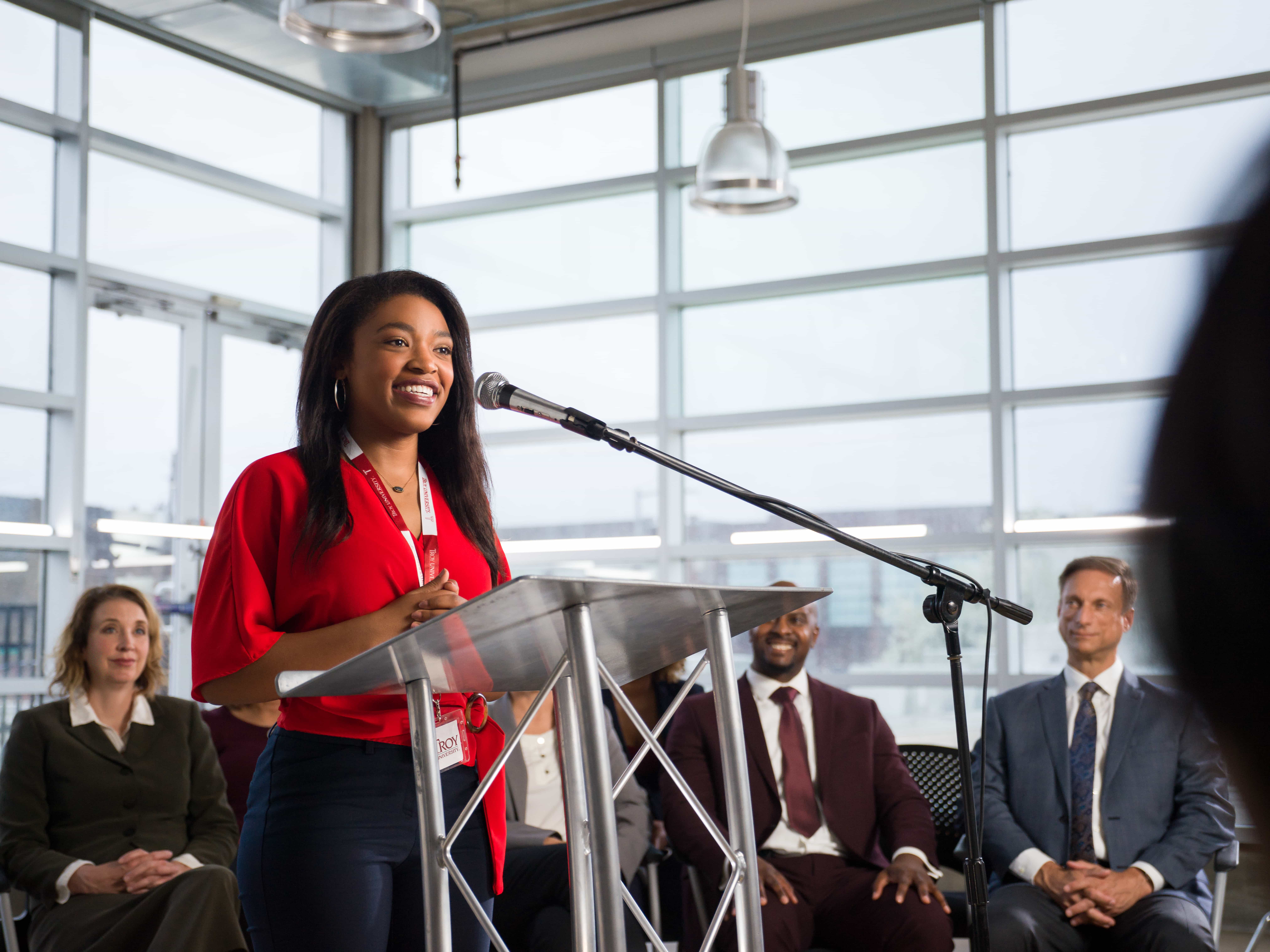Troy student speaking at a podium to an audience.
