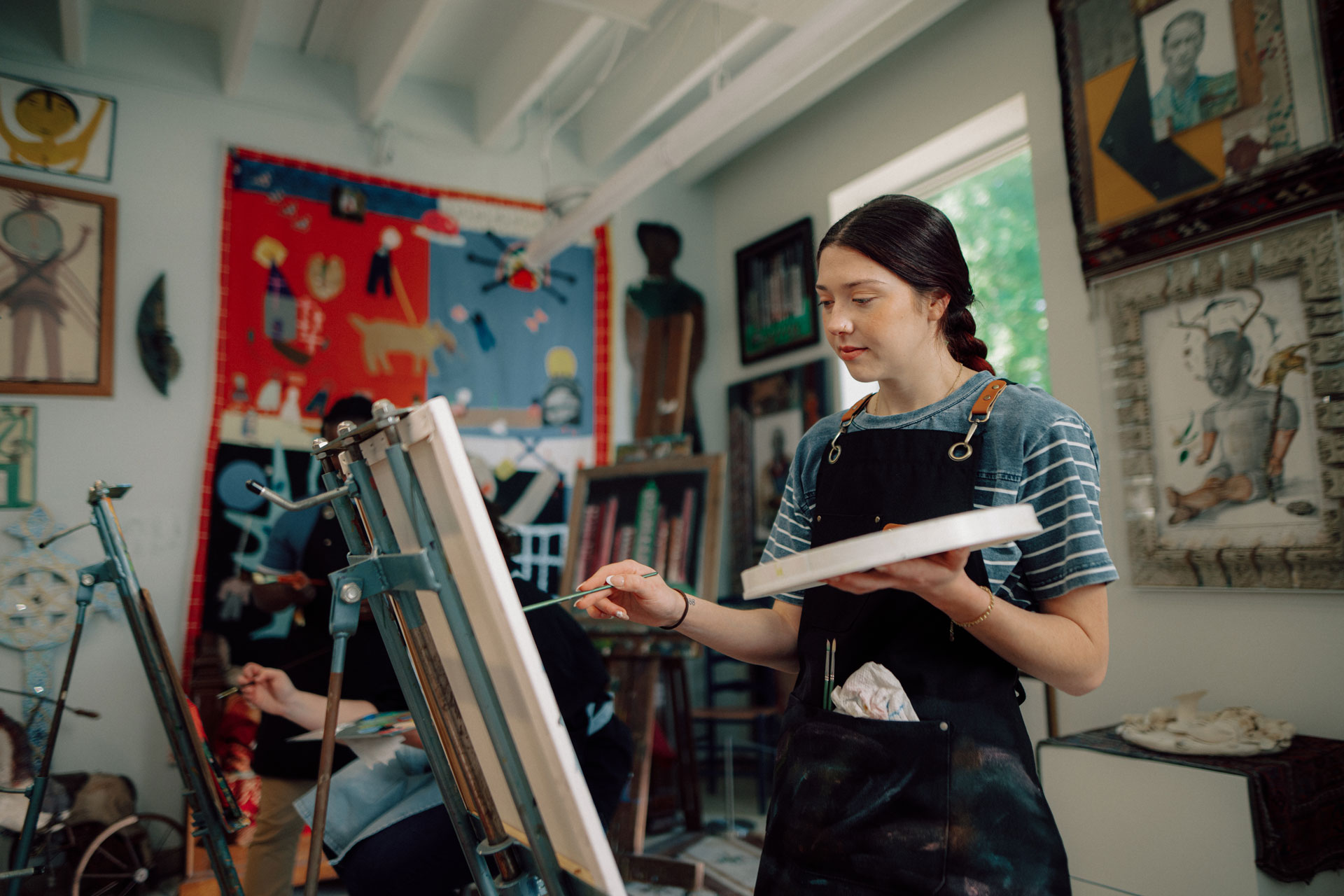 An art major student paints in a studio.