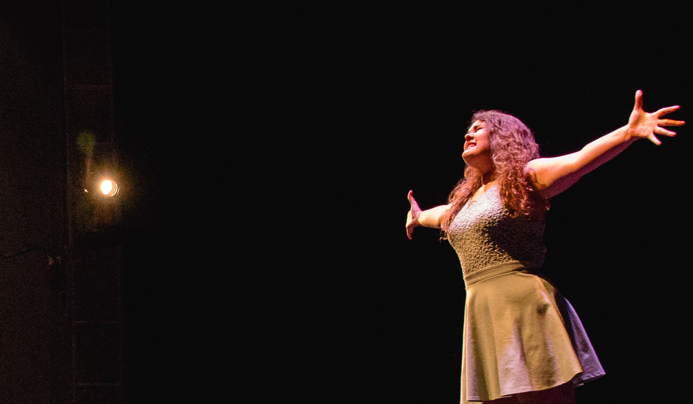 Audition A young woman on stage with arms outstretched
